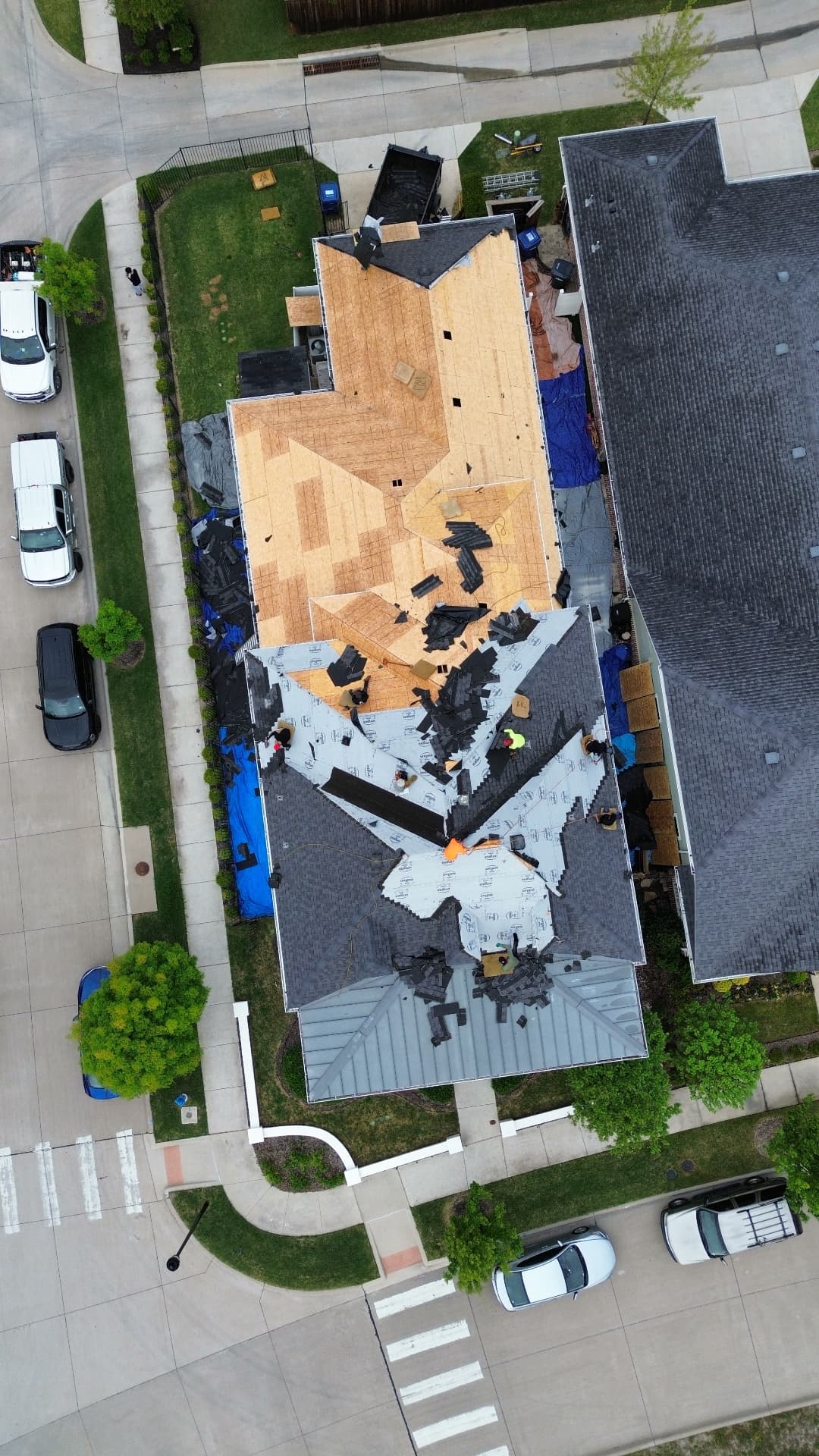 Roof replacement in progress with exposed decking and underlayment viewed from above