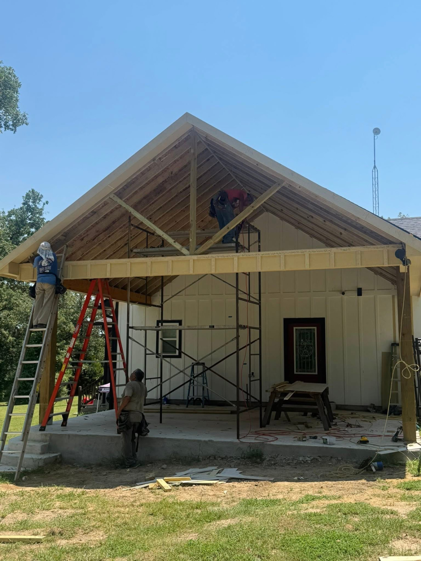 Patio cover being built with exposed roof framing and scaffolding