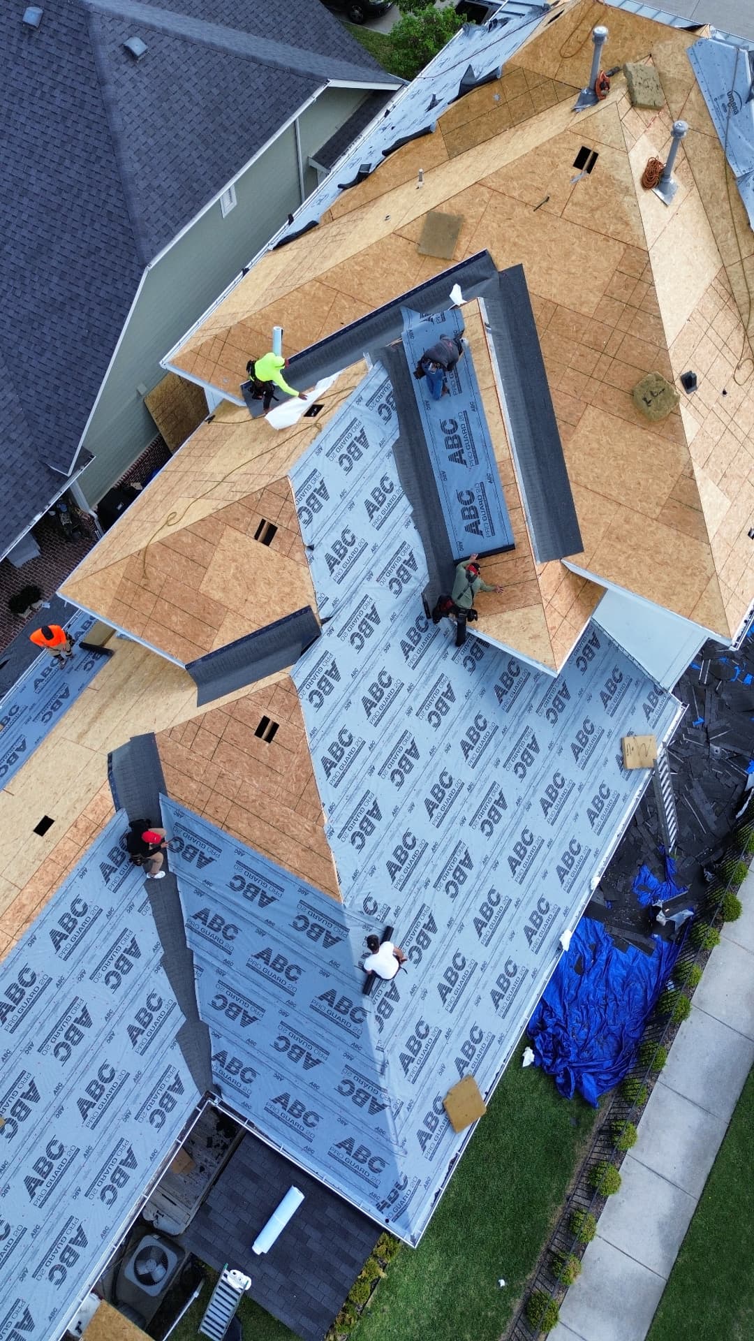 Yearby roof replacement in progress, aerial view 1: exposed decking and roofing underlayment