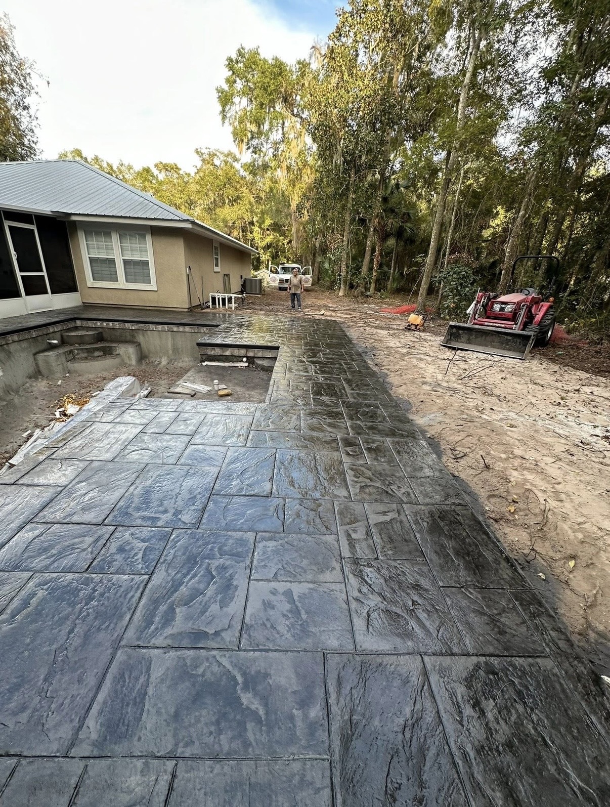 Long gray stamped concrete patio with a stone-style pattern