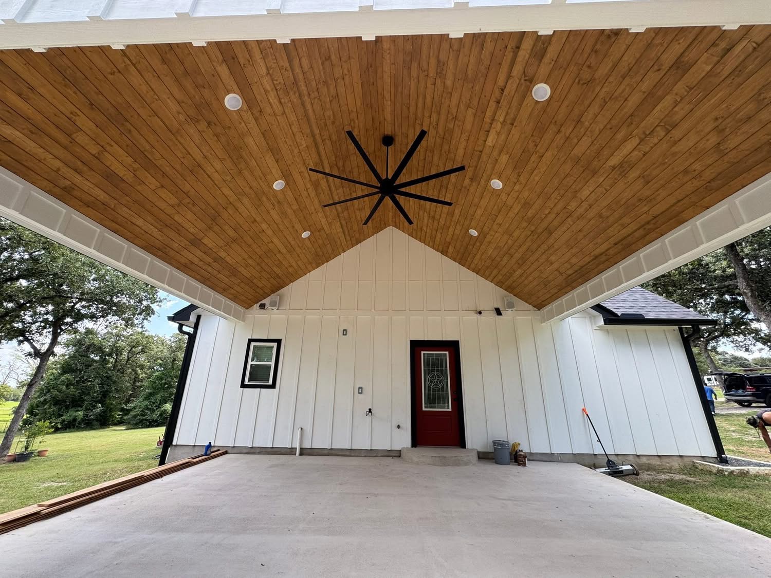 Covered patio with a wood ceiling, recessed lights and a black ceiling fan