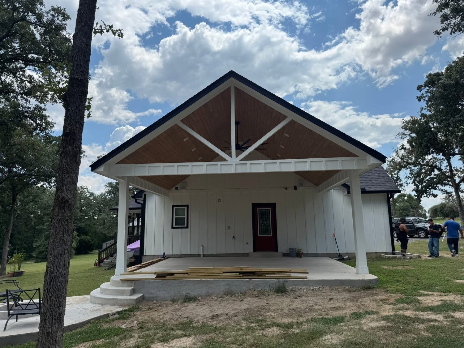 Front view of a gable patio cover with white posts and decorative roof framing